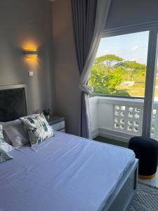 une chambre avec un lit et une grande fenêtre dans l'établissement Resort-style living apartment, à Zanzibar City