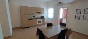 a kitchen with a table and a kitchen with a stove at Casa vacanze Pabaule in Gonnesa