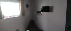 a corner of a room with a television and a window at 198 Headwards Retreat in Hemsby