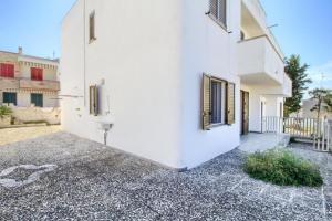 a white house with a courtyard and a building at Casa vacanze torre vado in Marina di Pescoluse