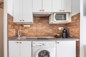 a kitchen with a washing machine and a microwave at Seaside Serenity in Denia in Denia