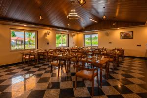 un ristorante con tavoli e sedie su un piano a scacchi di Aashiyana Luxury Cottages a Khilchīpur