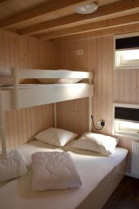 a bed in a room with two bunk beds at Sisters Beachbungalows in Katwijk aan Zee