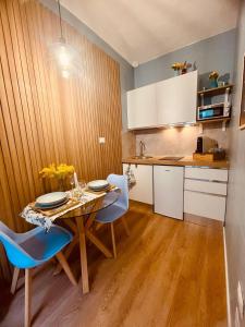 a kitchen with a wooden table and blue chairs at Il Sogno nel Cassetto HOME in Bari