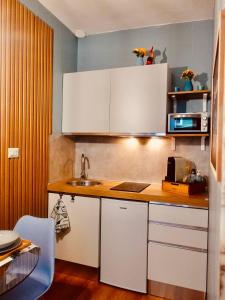 a kitchen with white cabinets and a sink at Il Sogno nel Cassetto HOME in Bari