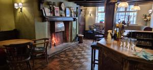 a bar with a fireplace in a pub with a table at The Talbot Hotel in Ledbury