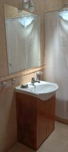 a bathroom with a sink and a mirror and a shower at temporary rental Mendoza in Guaymallen +11 photos