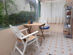 a table and chairs in a room with a window at Giverny, Cosy studio au vert in Giverny