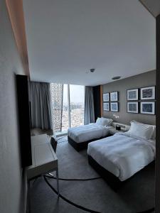 a hotel room with two beds and a television at 4Leisure Suites DAMAC Esclusiva Towers in Riyadh