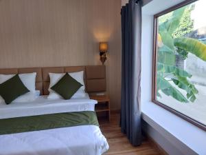 a bedroom with a bed and a large window at Comfy Cool Breeze by eMzaz in Dhiffushi