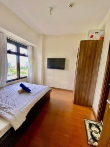 a bedroom with a bed and a large window at 1 Bedroom with balcony azalea condo in Cebu City
