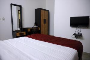 a bedroom with a bed and a flat screen tv at NIDHI RESIDENCY in Guruvāyūr