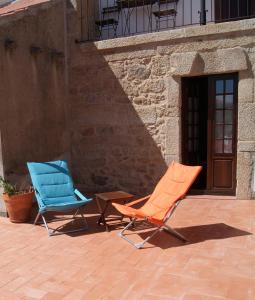 two chairs sitting on a patio next to a building at Casa d'Acha in São Miguel de Acha