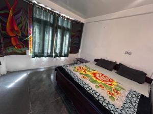 ein Schlafzimmer mit einem Bett, das mit einer Blumendecke bedeckt ist in der Unterkunft FORMOSA Cafe Hostel KASOL GOA in Kasol
