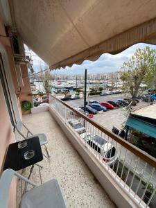 een balkon met uitzicht op een parkeerplaats bij Cozy Apartment View Pasalimani in Piraeus