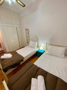 een kamer met twee bedden en een bank erin bij Cozy Apartment View Pasalimani in Piraeus