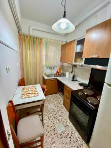 een kleine keuken met een kleine tafel en een tafel en stoelen bij Cozy Apartment View Pasalimani in Piraeus +6 foto's