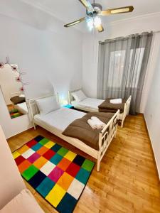 two beds in a room with a colorful rug at Cozy Apartment View Pasalimani in Piraeus +6 photos
