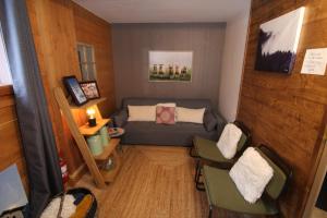 a small living room with a couch and chairs at Chalet Le Panicaut in Levassaix