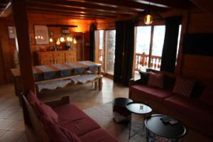 a living room with couches and tables and windows at Chalet Le Panicaut in Levassaix