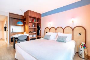 a bedroom with a large white bed and a desk at Appartements RockyPop Marseille in Marseille