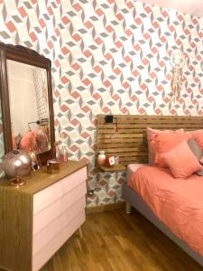 a bedroom with a mirror and a bed and a dresser at Appartement Plage Malo les bains avec confort in Dunkerque +16 photos