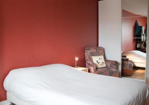 a bedroom with a bed and a chair at Spacious home near Canal and Stadium with Wifi in Reims