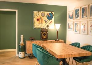 a dining room with a wooden table and green chairs at Spacious home near Canal and Stadium with Wifi in Reims