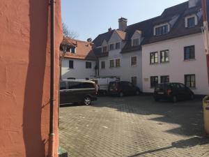 eine Gruppe von Autos, die auf einem Parkplatz geparkt sind in der Unterkunft Kulisse Apartments in Günzburg