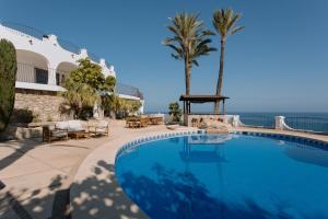 a large swimming pool next to a resort with the ocean at Villa Bora Montiboli by Buccara in Villajoyosa