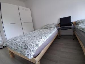 a bedroom with a bed and a chair in it at Pension Ronnys wilde Wiese in Belgershain