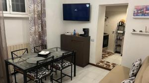 a living room with a table and chairs and a television at Residenza da Ste in Maslianico