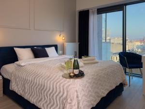 a bedroom with a bed with a bottle of wine and glasses at URBAN APARTMENTS GLOBAL PREMIUM 8th floor no 16, Free Garage, Self Check-in, No Deposit in Katowice +17 photos