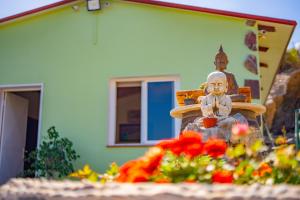 a statue in a garden with flowers in front of a house at Casa Rural Buda Terra in Santa Cruz de Tenerife