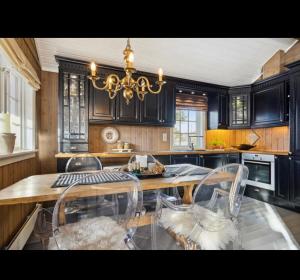 a kitchen with a table and chairs and a chandelier at Bjorli Mountain Cabin in Bjorli