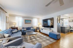 a living room with blue couches and a tv at Ann Acres --- 21069 Elizabeth Ave. in Rehoboth Beach