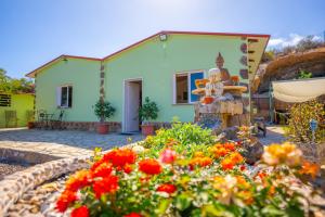 a house with a garden with flowers in front of it at Casa Rural Buda Terra in Santa Cruz de Tenerife