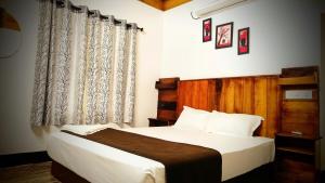 a bedroom with a bed and a large window at 2Bhk Vacation Home Munnar, Adimaly in Anniyartholu