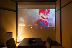 a projection screen with a mario game on it at 東雲庵/shinonomean in Kyoto