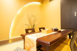 een eetkamer met een houten tafel en stoelen bij 東雲庵/shinonomean in Kyoto