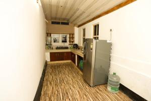 a kitchen with a stainless steel refrigerator in a room at 2Bhk Vacation Home Munnar, Adimaly in Anniyartholu