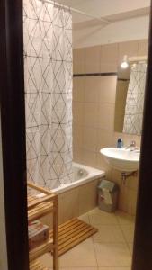 une salle de bain avec un rideau de douche et un lavabo dans l'établissement Les Terrasses de LOZARI de Nadine et Claude, à Belgodère 21 autres photos