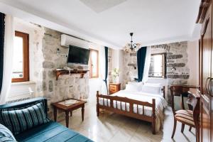 - une chambre avec un lit et un canapé dans l'établissement Art Hotel Galathea, à Kotor