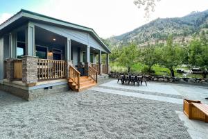 a house with a porch and a patio with tables at Water's Edge Escape in Chelan