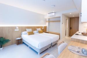 卡斯特尔德费尔斯Fels Apartments的卧室里有一张白色的大床和一张桌子