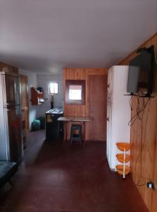 a living room with a refrigerator and a kitchen at Cabaña en el bosque in La Ligua