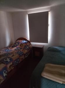 a small bedroom with two beds and a window at Cabaña en el bosque in La Ligua