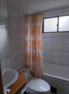 a bathroom with a toilet and a sink and a window at Cabaña en el bosque in La Ligua