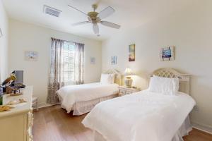 una camera da letto con due letti e un ventilatore a soffitto di Villa Bonita Sol a Naples Altre 66 foto