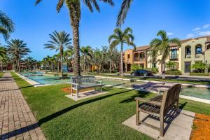 un parco con panchine e palme di fronte a un edificio di Villa Bonita Sol a Naples